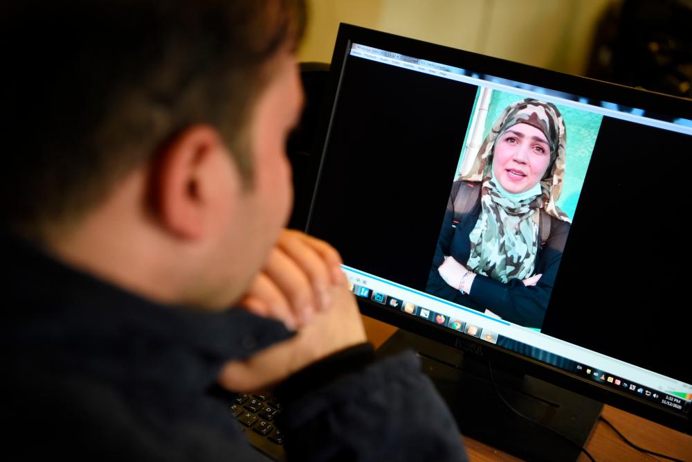 In this picture taken on November 12, 2020, a man watches a video of Afghan woman Muzghan, who walked free from jail in September after confessing to being members of the Taliban's ultra-violent Haqqani network, on a computer screen in Kabul. — AFP