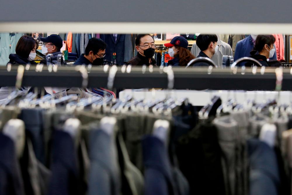 People wearing masks to prevent contracting the coronavirus wait in line to buy masks at a department store in Seoul, South Korea February 27, 2020. - Reuters