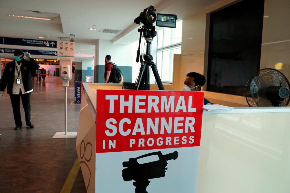 A health quarantine officer waits for passengers at a thermal screening point at the international arrival terminal of Kuala Lumpur International Airport 2 in Sepang, January 27, 2020. - Reuters