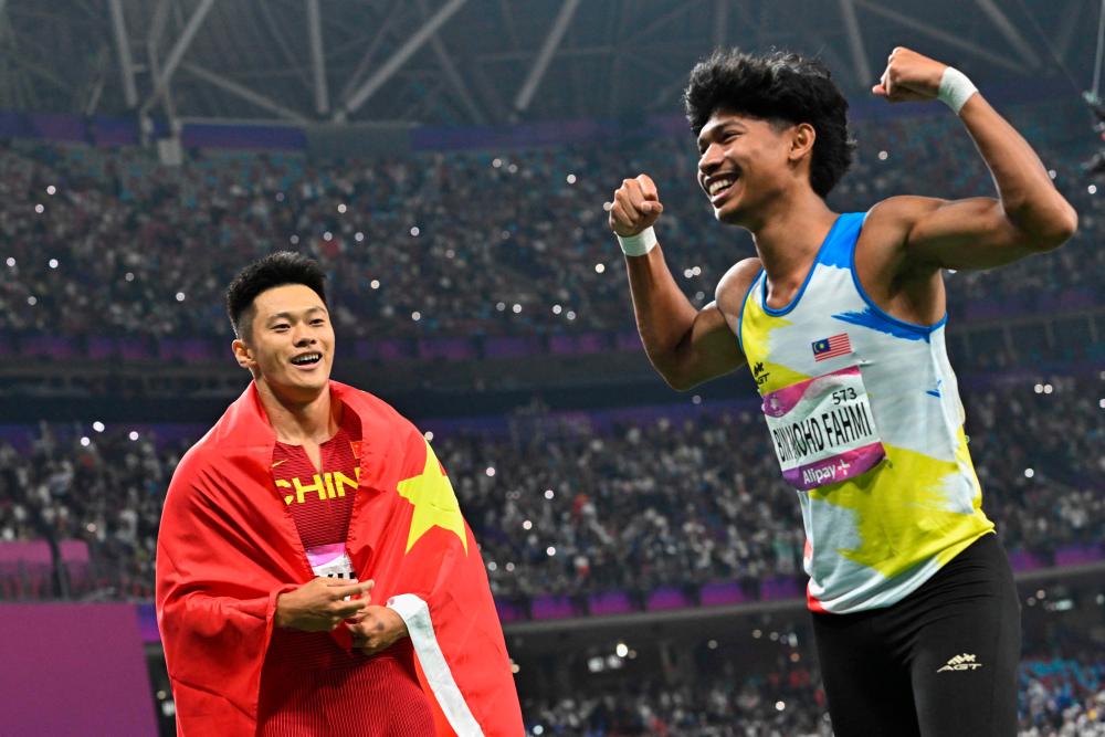 Gold medallist China’s Xie Zhenye (L) and bronze medallist Malaysia’s Muhd Azeem Fahmi celebrate after the men’s 100m final athletics event during the 2022 Asian Games in Hangzhou in China’s eastern Zhejiang province on September 30, 2023. AFPPIX