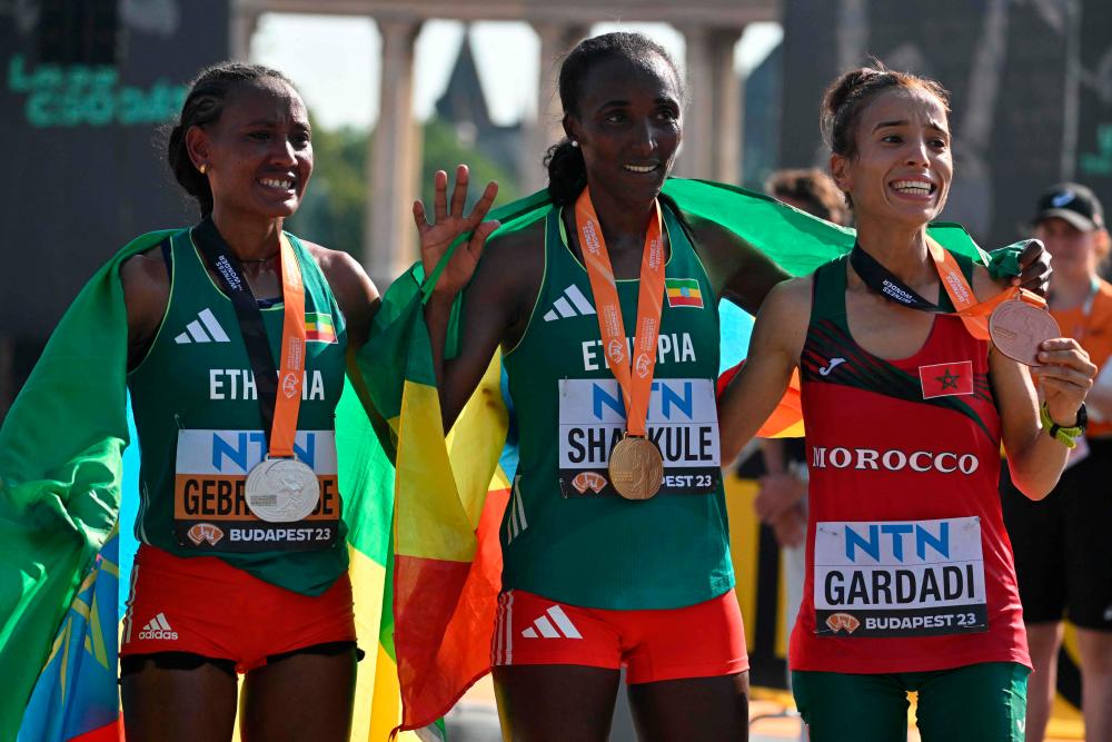 Gold medallist Ethiopia's Amane Beriso Shankule poses with silver medallist Ethiopia's Gotytom Gebreslase (L) and bronze medallist Morocco's Fatima Ezzahra Gardadi (R) after the women's marathon final during the World Athletics Championships in Budapest on August 26, 2023. - AFPPIX