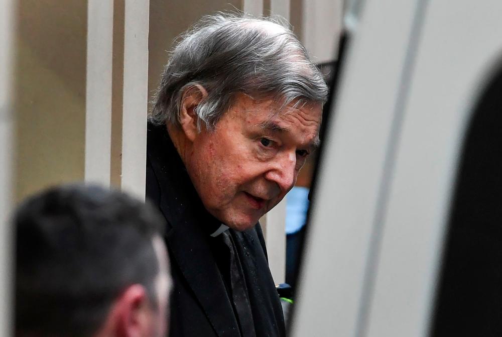 Australian Cardinal George Pell (C) is escorted in handcuffs from the Supreme Court of Victoria in Melbourne on August 21, 2019. — AFP