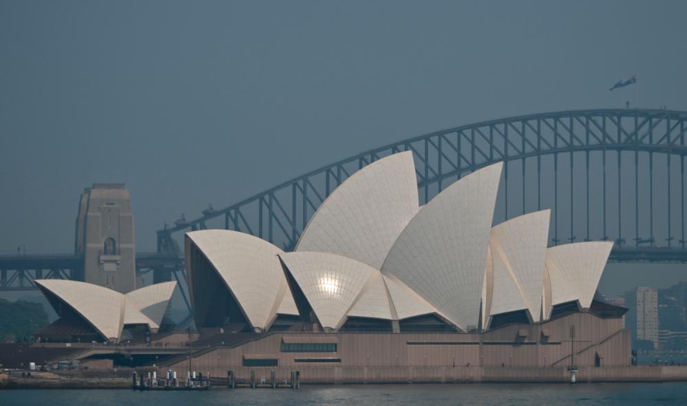 The Sydney Opera House and Harbour Bridge are seen through a smokey haze which blankets Sydney on Nov 21. — AFP