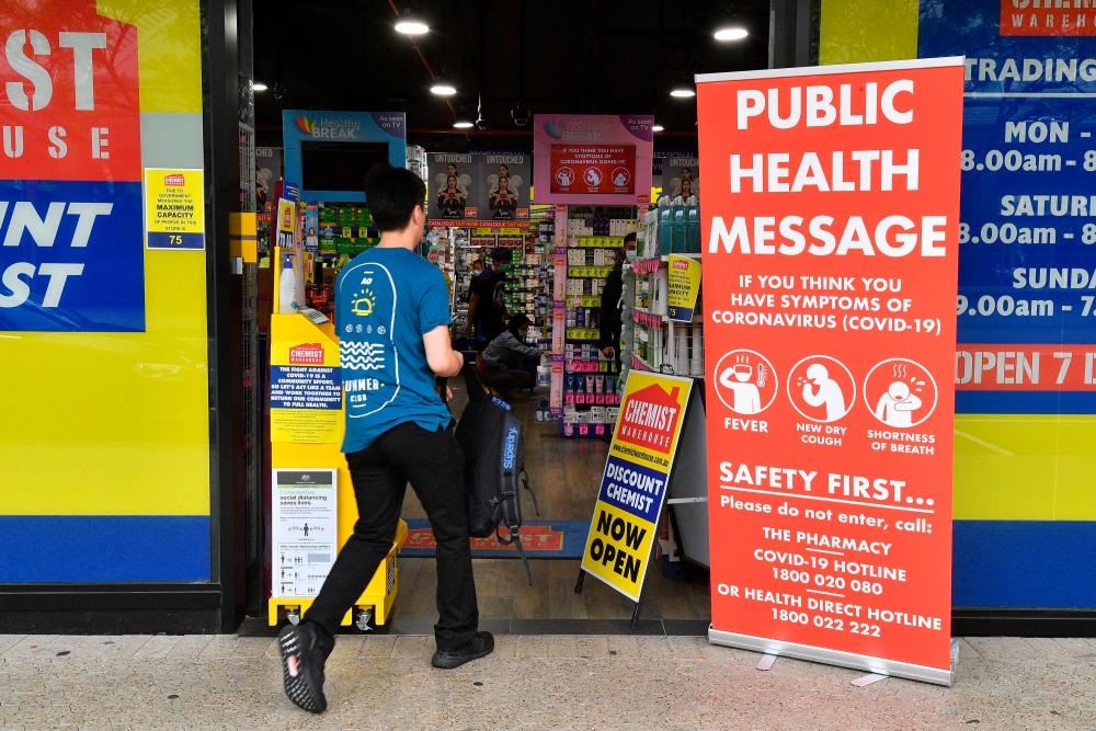 A man enters a pharmacy in Sydney on March 27, 2020, as people stay away due to restrictions to stop the spread of the worldwide Covid-19 coronavirus outbreak. — AFP