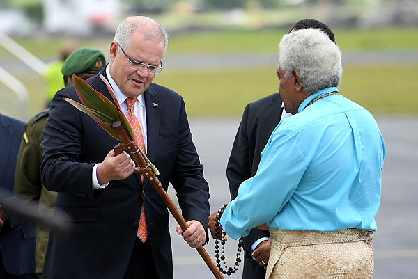 Australian Prime Minister Scott Morrison is presented with a gift as he arrives in Port Vila, Vanuatu — Reuters