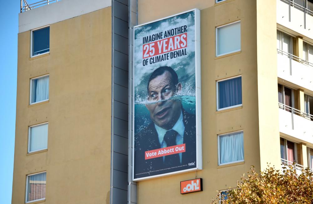 Photo taken on May 12, 2019 shows a pro climate change election sign in Sydney featuring climate change skeptic and former prime minister Tony Abbott ahead of the Australian election. — AFP