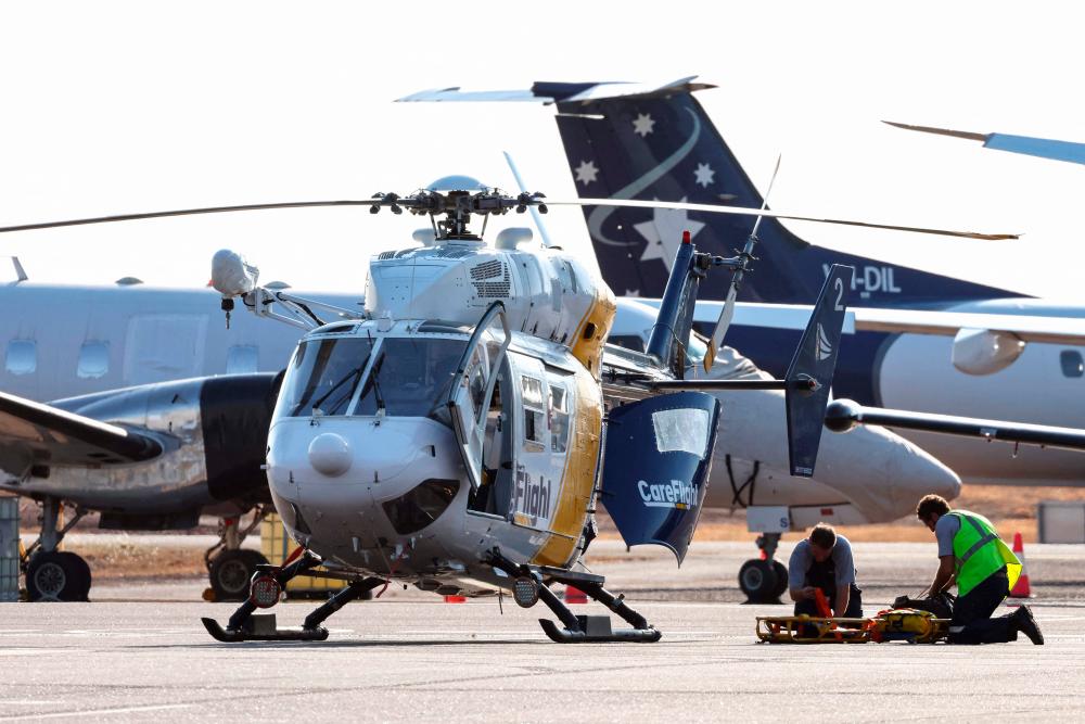 A Care Flight helicopter is seen on the tarmac of the Darwin International Airport in Darwin on August 27, 2023, as rescue work is in progress to transport those injured in the US Osprey military aircraft crash at a remote island north of Australia's mainland. AFPPIX