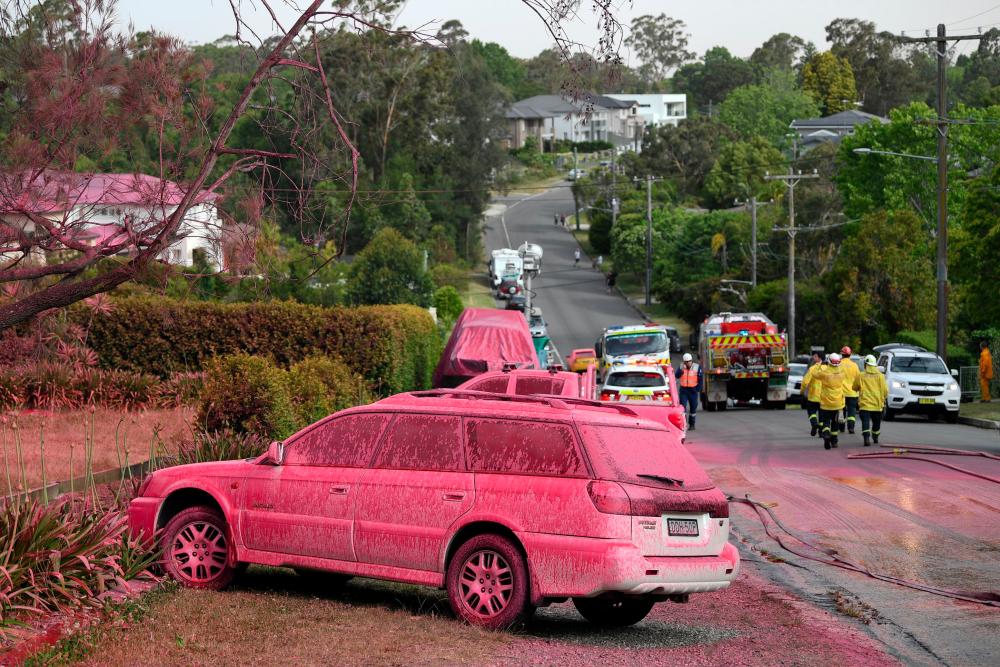 A car sprayed with fire retardant is seen after a bushfire in the residential area of Sydney on Nov 12. — AFP