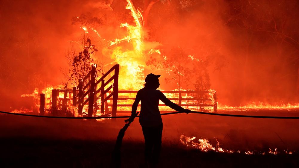 Residents defend a property from a bushfire at Hillsville near Taree, 350km north of Sydney on Nov 12. — AFP