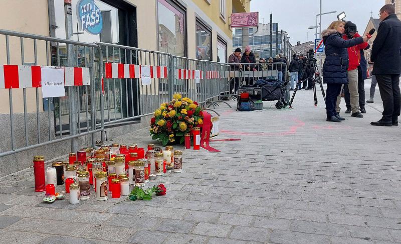 Candles and flowers are placed on February 16, 2025 at the site where a man randomly attacked passers-by with a knife and stabbed to death a teenager and wounded five other people in Villach, Austria. A 23-year-old Syrian asylum seeker was arrested after the stabbing on February 15, 2025. A passing food delivery rider -- also from Syria -- intervened, ramming his vehicle into the attacker, who was lightly hurt and was arrested “right after the attack”, a police spokesman said. PETER LINDNER / APA / AFP