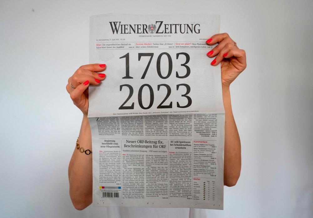 A woman holds the current issue of the “Wiener Zeitung” newspaper from April 27, 2023, with its front page illustrating the newspaper’s age of 320 years, in Vienna, Austria, on April 27, 2023/AFPpix