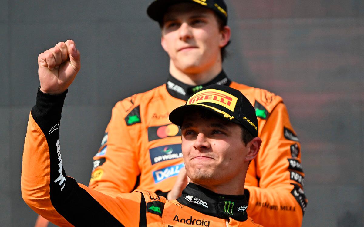 McLaren’s British driver Lando Norris celebrates on the podium after winning the Formula One Hungarian Grand Prix at the Hungaroring circuit in Mogyorod near Budapest, Hungary, on August 3, 2025; behind him in background can be seen second placed McLaren’s Australian driver Oscar Piastri. - Attila KISBENEDEK / AFP