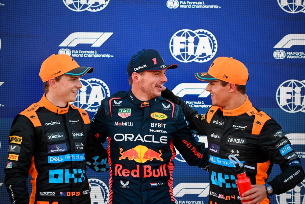 McLaren's Australian driver Oscar Piastri (L), Red Bull Racing's Dutch driver Max Verstappen (C) and McLaren's British driver Lando Norris pose after taking the pool in the qualifying session for the Formula One Japanese Grand Prix at the Suzuka circuit, Mie prefecture on September 23, 2023//AFPix