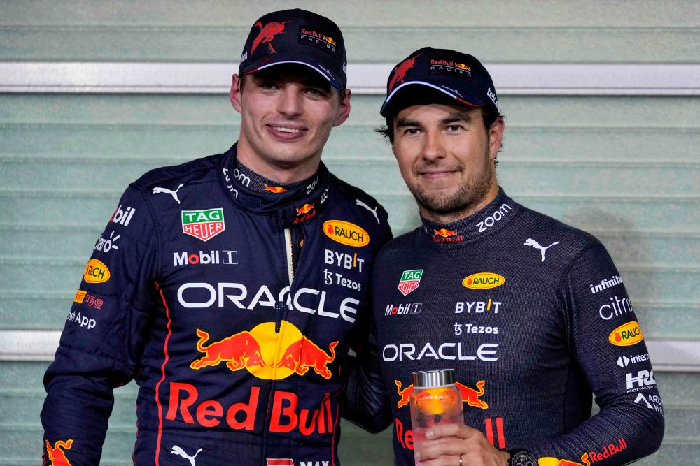 Red Bull’s Dutch driver Max Verstappen (L) and Red Bull’s Mexican driver Sergio Perez pose for a picture after the qualifying session on the eve of the Abu Dhabi Formula One Grand Prix at the Yas Marina Circuit in the Emirati city of Abu Dhabi on November 19, 2022. AFPPIX