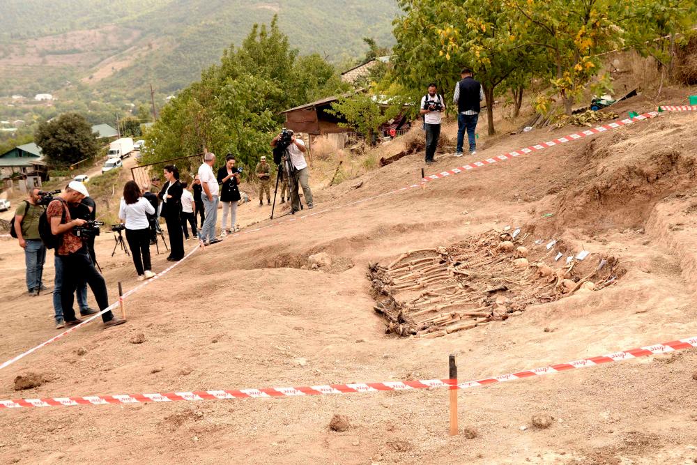 A picture taken on October 4, 2022 shows human remains at the site of a mass grave discovered in the village of Edilli. AFPPIX