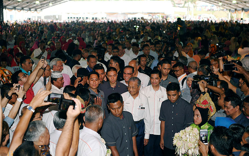 Prime Minister Tun Dr Mahathir Mohamad and Economic Affairs Minister Datuk Seri Mohamed Azmin Ali are greeted by guests, as they arrive for the National-Level Felda Settlers’ Day 2019 celebration at Felda Selancar 3, on July 7, 2019. — Bernama