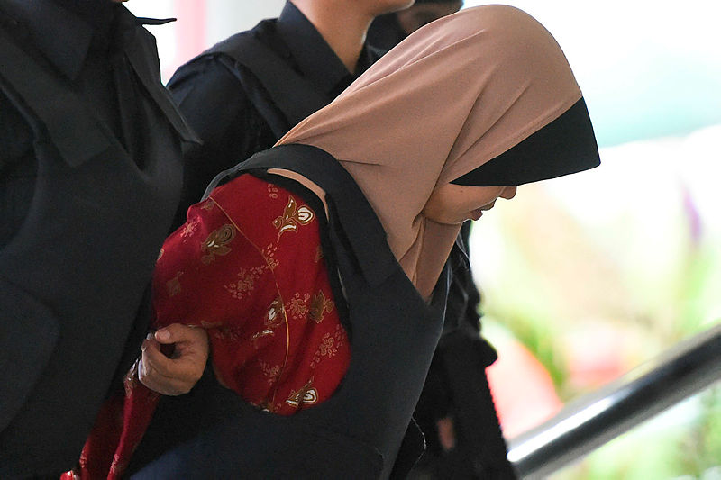 Indonesian national Siti Aisyah is escorted by Malaysian police for a special court session to rule on witness statements at the Shah Alam High Court, outside Kuala Lumpur on December 14, 2018 — AFP