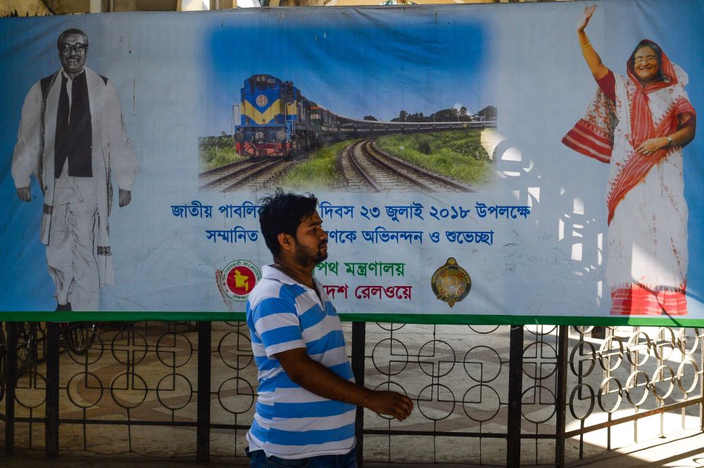 A Bangladeshi man walks past a poster with the images of Sheikh Mujibur Rahman (L), founding father of Bangladesh, and Bangladeshi Prime Minister Sheikh Hasina at Kamalapur railway station in the Bangladeshi capital Dhaka Jan 1, 2019. — AFP