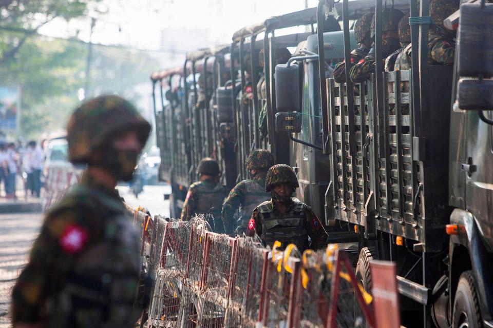 FILE PHOTO: Soldiers stand next to military vehicles as people gather to protest against the military coup, in Yangon, Myanmar, February 15, 2021. REUTERSPIX