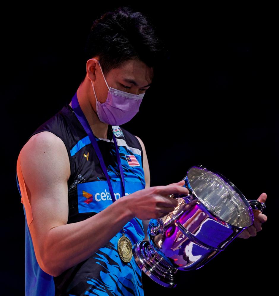 $!Malaysia’s Lee Zii Jia looks at the winner’s trophy after beating Denmark’s Viktor Axelsen during the men’s singles final on the last day of the All England Open Badminton Championship at the Utilita Arena in Birmingham, central England, on March 21, 2021. / AFP