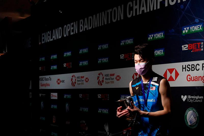 $!Malaysia’s Lee Zii Jia is interviewed remotely holding the winner’s trophy after beating Denmark’s Viktor Axelsen during the men’s singles final on the last day of the All England Open Badminton Championship at the Utilita Arena in Birmingham, central England, on March 21, 2021. / AFP