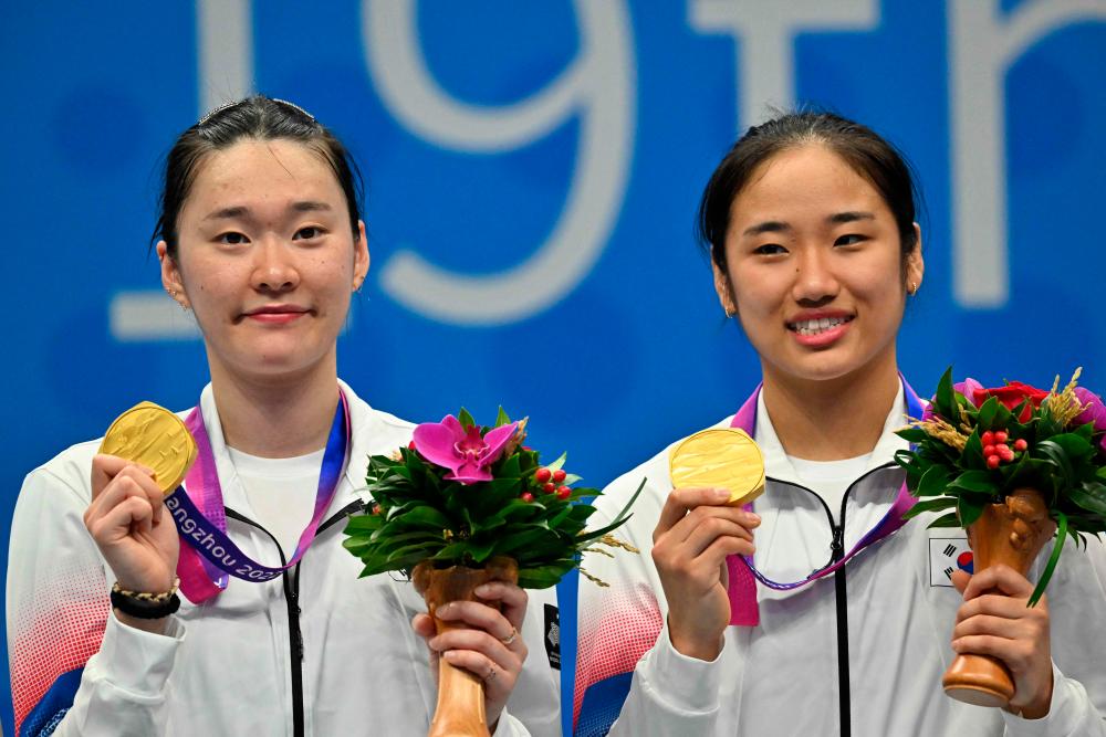 Gold medallists South Korea’s An Se-young (R) and Kim Ga-eun celebrate during the medals ceremony for the women’s team badminton event at the 2022 Asian Games in Hangzhou in China’s eastern Zhejiang province on October 1, 2023. - AFPPIX