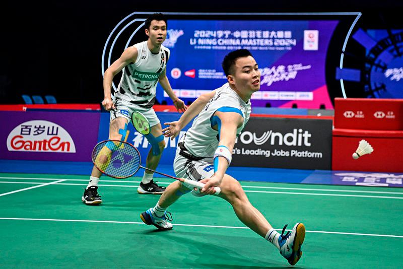 Malaysia's Aaron Chia (R) and Soh Wooi Yik play against China's He Jiting and Ren Xiangyu during the men's doubles quarter-final match of the BWF World Tour China Masters 2024 badminton tournament in Shenzhen, in southern China's Guangdong province on November 22, 2024. - STRINGER / AFP