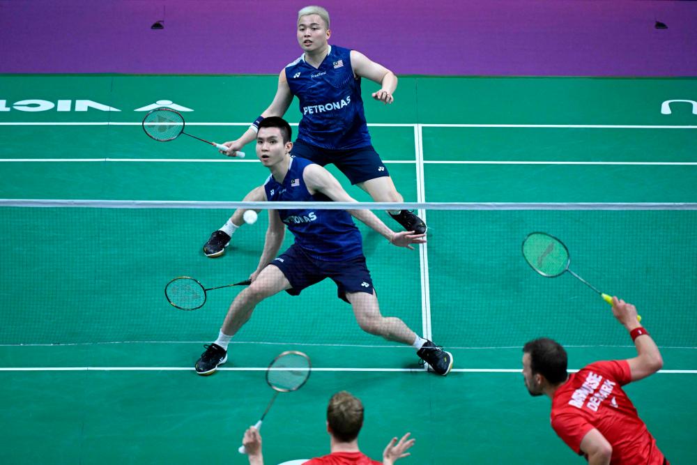 Aaron Chia and Soh Wooi Yik (front) hit a return against Denmark’s Kim Astrup and Anders Skaarup Rasmussen during their men’s doubles quarter-final match at the 2023 Sudirman Cup world badminton championships in Suzhou in China’s eastern Jiangsu province on May 19, 2023. AFPPIX