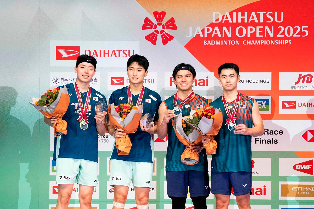 Winners South Korea's Kim Won-ho and Seo Seung-jae (L) and runners-up Malaysia's Goh Sze Fei and Nur Izzuddin pose on the podium after their men's doubles final match on the final day of the Japan Open badminton tournament at Tokyo Gymnasium in Tokyo on July 20, 2025. - Yuichi YAMAZAKI / AFP