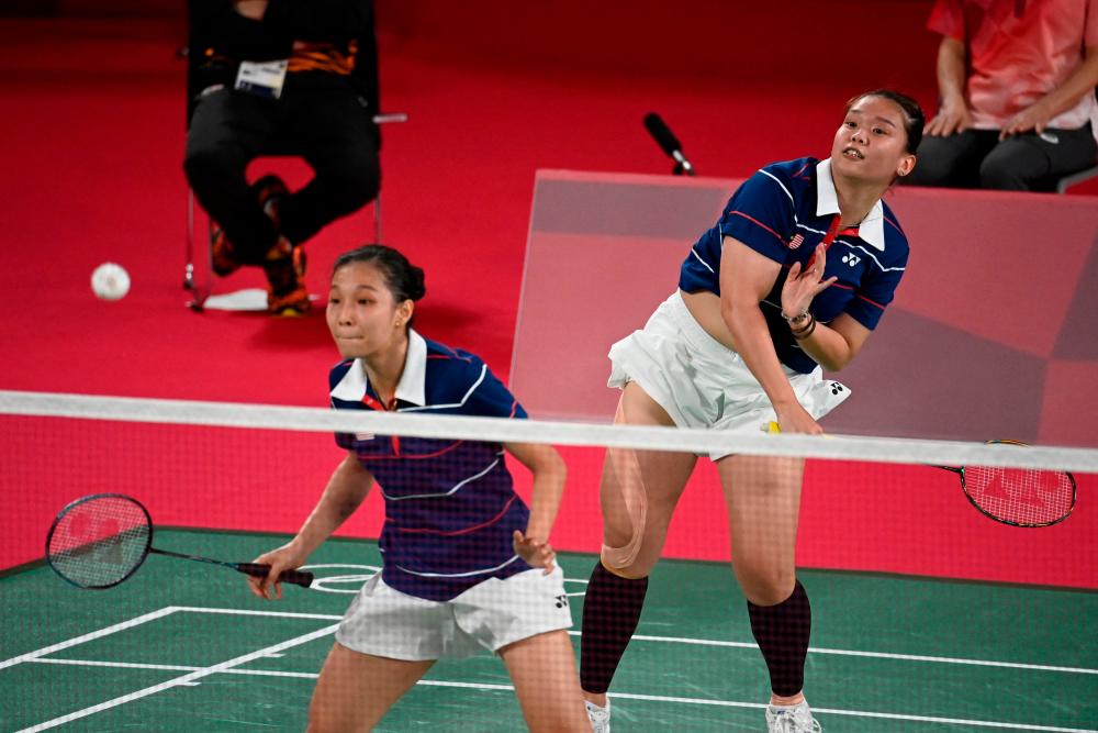 Malaysia’s Lee Meng Yean looks on as Malaysia’s Chow Mei Kuan (R) hits a shot in their women’s doubles badminton group stage match against Indonesia’s Greysia Polii and Indonesia’s Apriyani Rahayu during the Tokyo 2020 Olympic Games at the Musashino Forest Sports Plaza in Tokyo on July 24, 2021. -AFP