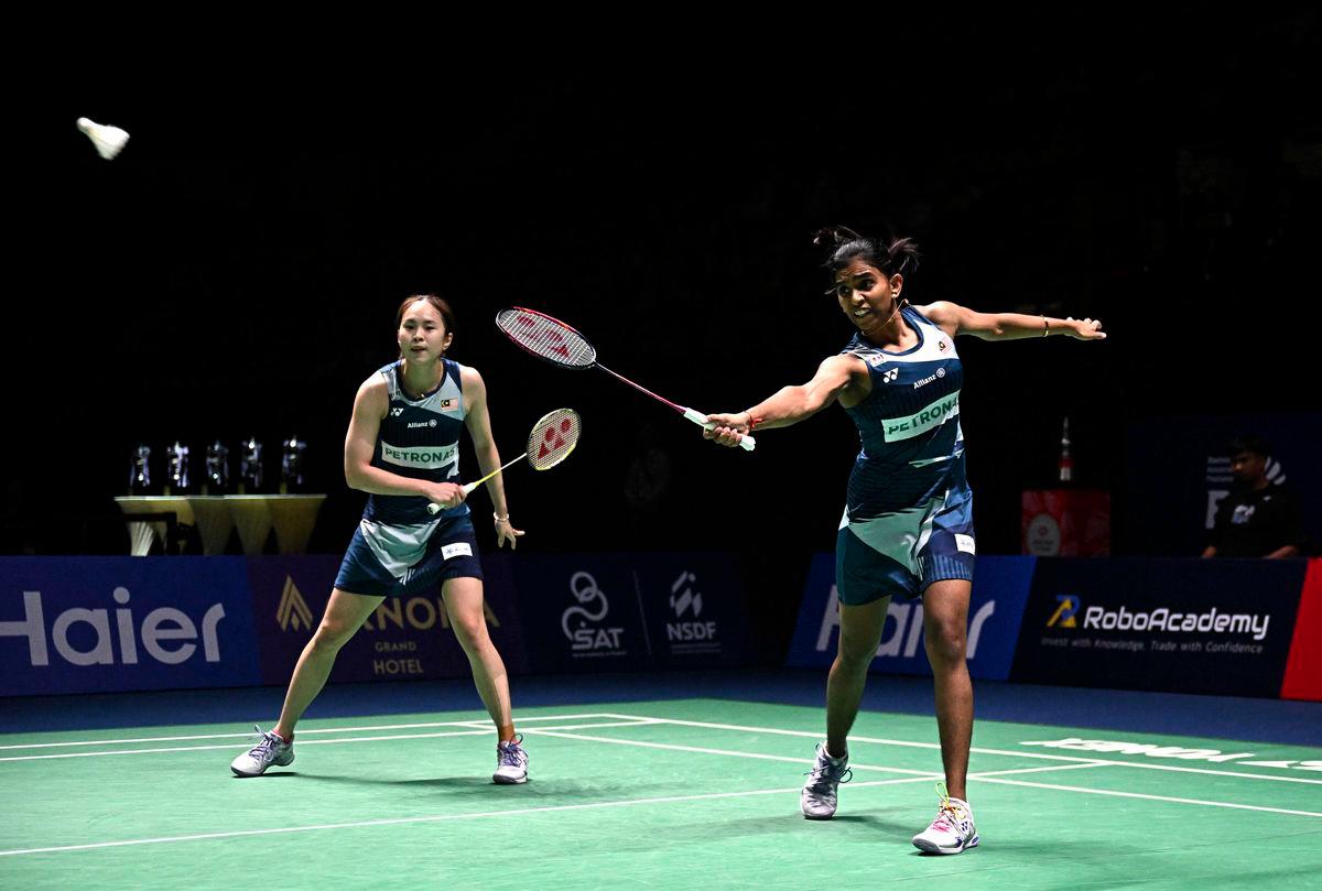 Thinaah Muralitharan (R) hits a return as teammate Pearly Tan (L) looks on against South Korea’s Jeong Na-eun and Lee Yeon-woo during the women’s doubles final at the 2025 Thailand Open badminton tournament in Bangkok on May 18, 2025. - AFPPIX