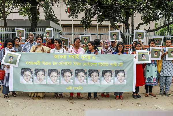 In this photo taken on April 12, 2019 Bangladeshi women hold banners and photographs of schoolgirl Nusrat Jahan Rafi at a protest in Dhaka, following her murder by being set on fire after she had reported a sexual assault. — AFP