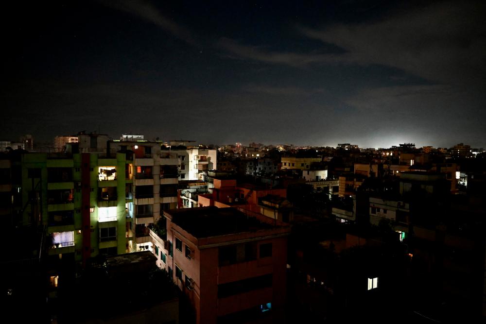 This photograph taken on October 4, 2022 shows a residential neighbourhood during a power blackout in Dhaka. At least 130 million people in Bangladesh were left without power on October 4 after a grid failure caused widespread blackouts, the government's power utility company said. - AFPPIX
