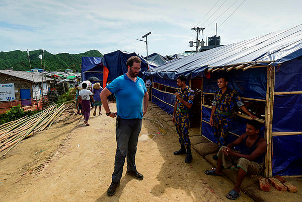 Officials of UN and Bangladesh police stand guard in front of a place where UN and refugee commission interviewed Rohingya families at a refugee camp in Teknaf on Aug 21.