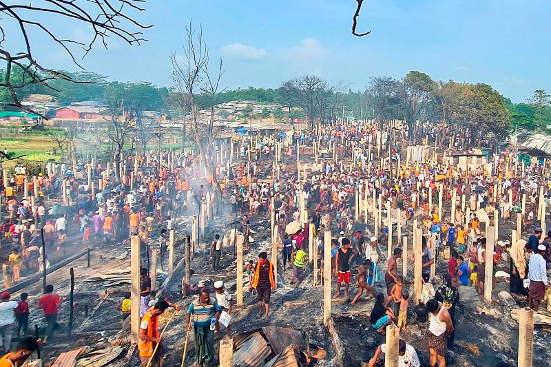 Rohingya refugees look through the debris of their houses charred by a fire at the Ukhia camp in Cox's Bazar on June 1, 2024. - AFPpix