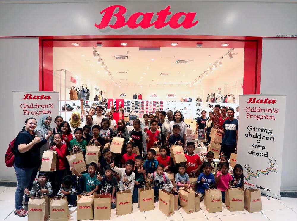 The children from Kampung Orang Asli Sungai Buloh with the Bata team. SUNPIX by NORMAN HIU