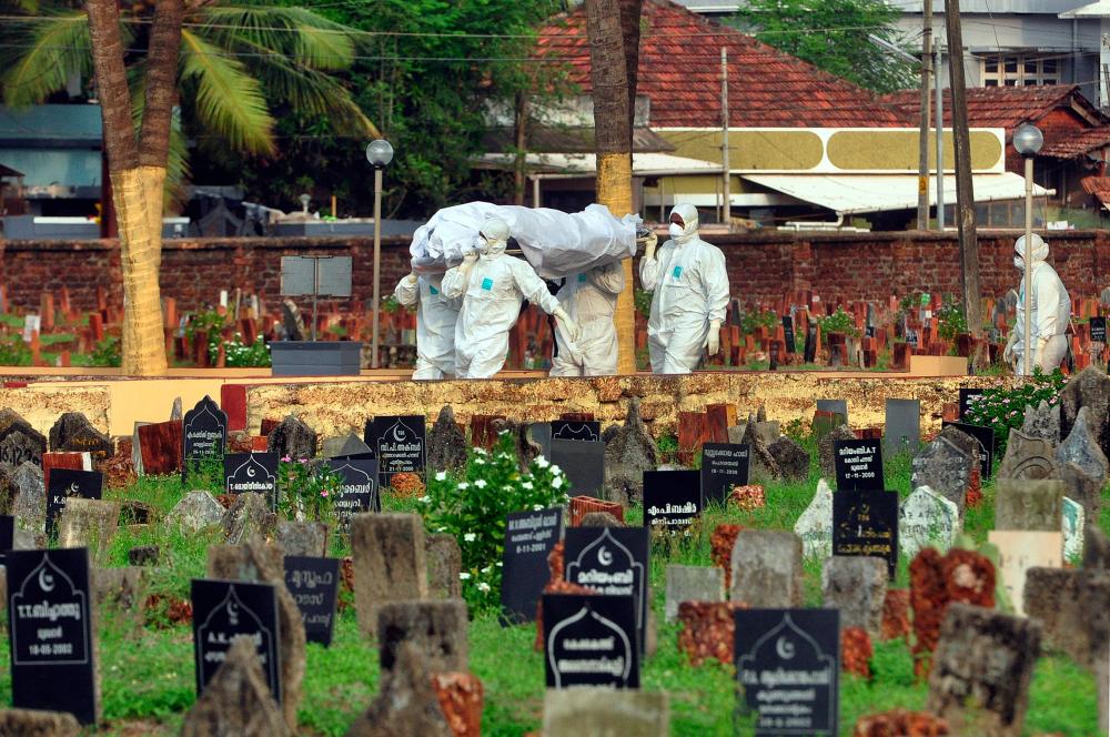Doctors and relatives wearing protective gear carry the body of a victim, who lost his battle against the brain-damaging Nipah virus, during his funeral at a burial ground in Kozhikode, in the southern Indian state of Kerala, India, May 24, 2018. - Reuters