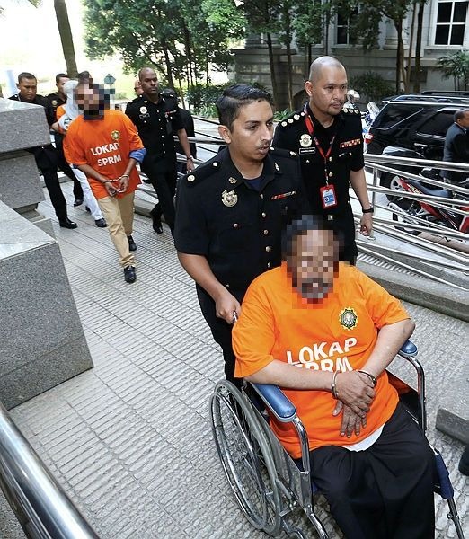 A Tan Sri (in the wheelchair) along with two individuals were brought to court to assist in investigations on the development of a piece of land belonging to the Jalan Bandar Sri Mahamariamman Temple in Kuala Lumpur at the Putrajaya magistrate’s court on March 7, 2019. — BBXpress.