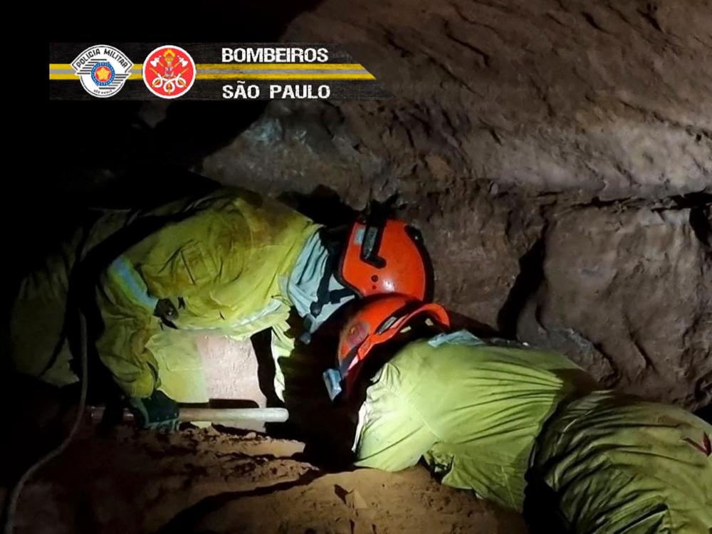Handout picture released from Sao Paulo State's Military Police on October 31, 2021 showing firefighters working to rescue civilian firefighters buried in a cave after a collapse in Altinopolis, Sao Paulo state, Brazil. Handout by Sao Paulo State’s Military Police via AFPpix
