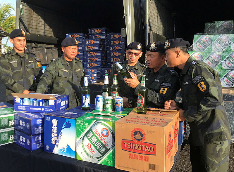 Tenth Battalion commanding officer Supt Sanudin Md Isa (2nd R) with other officers inspects the smuggled beer seized, on Jan 30, 2019. — Bernama