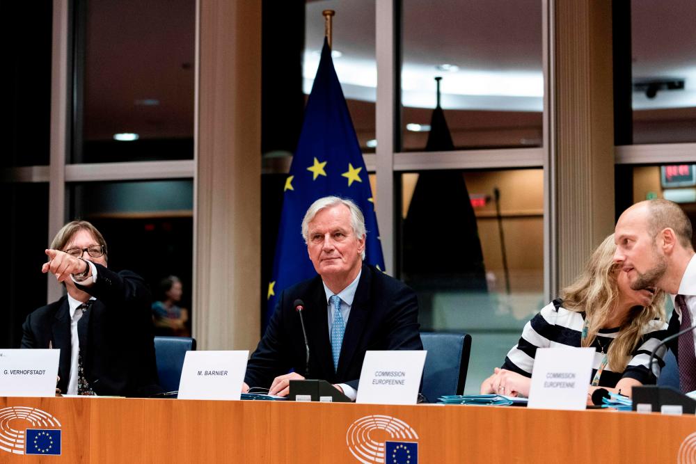 European Union's chief Brexit negotiator Michel Barnier (C) looks on prior to a meeting at the European Parliament in Brussels, on Oct 16, 2019. — AFP