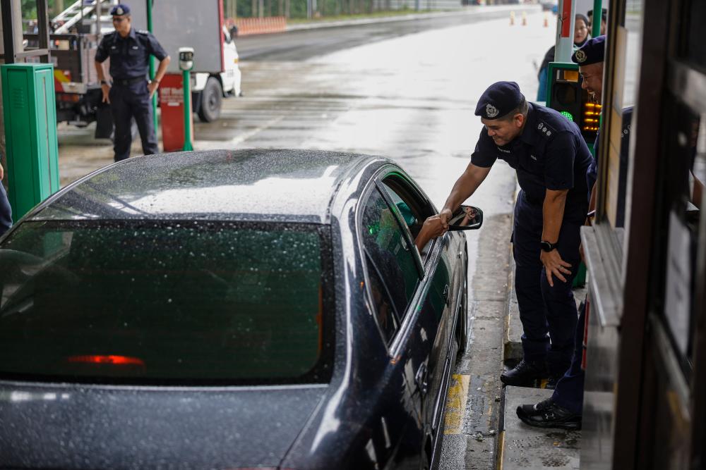KUALA LUMPUR, 20 April -- Ketua Jabatan Siasatan dan Penguatkuasaan Trafik Kuala Lumpur ACP Sarifudin Mohd Salleh mengucapkan selamat kepada warga kota yang pulang ke kampung pada Program Jom Balik Kampung di Plaza Tol Jalan Duta, hari ini. - fotoBERNAMA