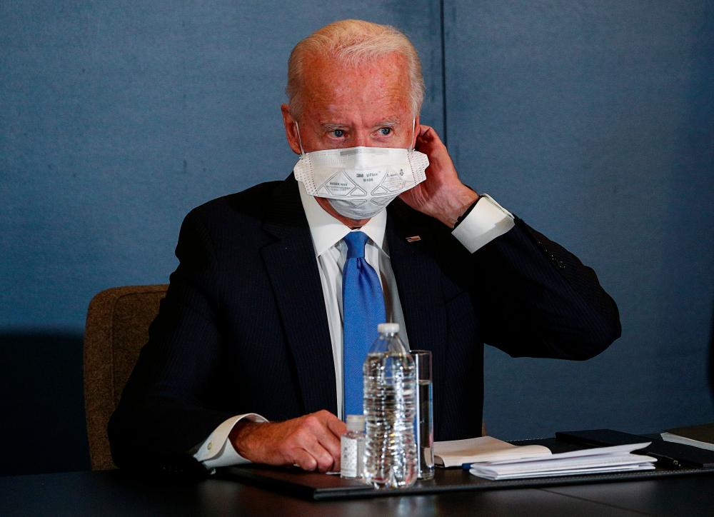 U.S. President-elect Joe Biden removes his face mask as he meets with Speaker of the House Nancy Pelosi (D-CA) and Senate Minority Leader Chuck Schumer (D-NY) at his transition headquarters in the Queen theater in Wilmington, Delaware, U.S., November 20, 2020. — Reuters