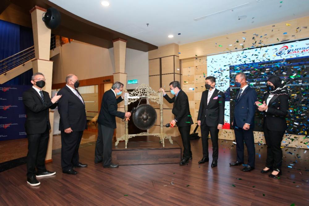 Coraza Integrated Technology Bhd executive chairman Tony Ng (third from left) and Lim striking the gong to signify the listing of Coraza at Bursa Malaysia.