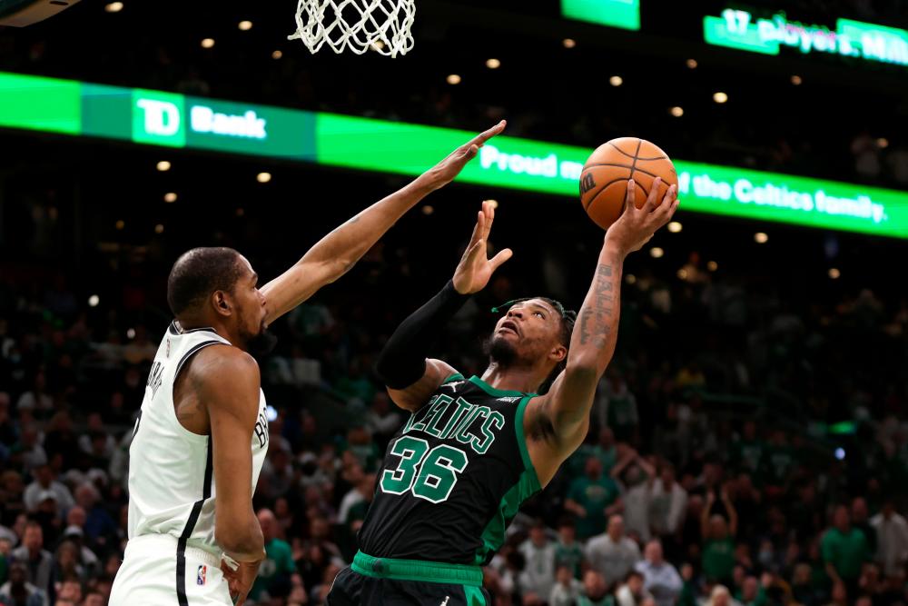 BOSTON, MASSACHUSETTS - APRIL 17: Marcus Smart #36 of the Boston Celtics takes a shot against Kevin Durant #7 of the Brooklyn Nets during the fourth quarter of Round 1 Game 1 of the 2022 NBA Eastern Conference Playoffs at TD Garden on April 17, 2022 in Boston, Massachusetts. AFPPIX