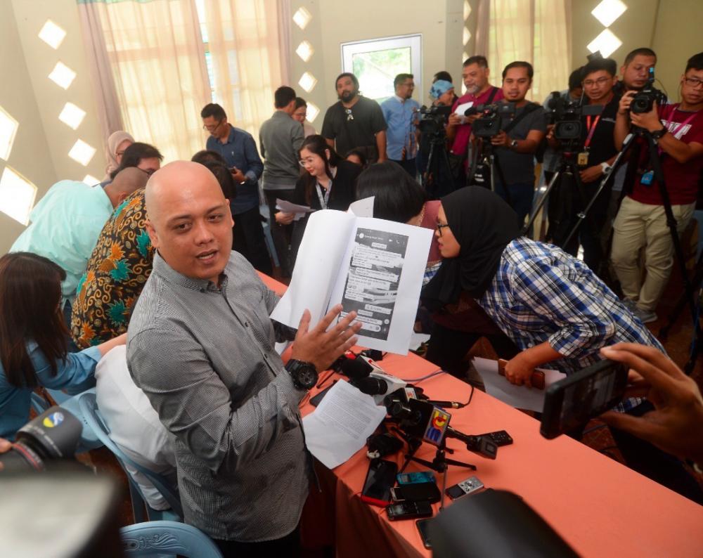 Sabah deputy PKR youth leader Blisson Zainuddin shows off printouts of the reported Whatsapp communications with Haziq Abdullah, at a press conference today.