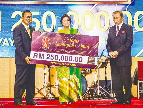 Tunku Puteri flanked by Albukhary Foundation senior adviser Datuk Mohd Puat Mohd Ali (left) and YSB finance chairman Datuk Syed Unan Mashri Syed Abdullah during the cheque presentation ceremony at the event. – ADIB RAWI YAHYA/THESUN