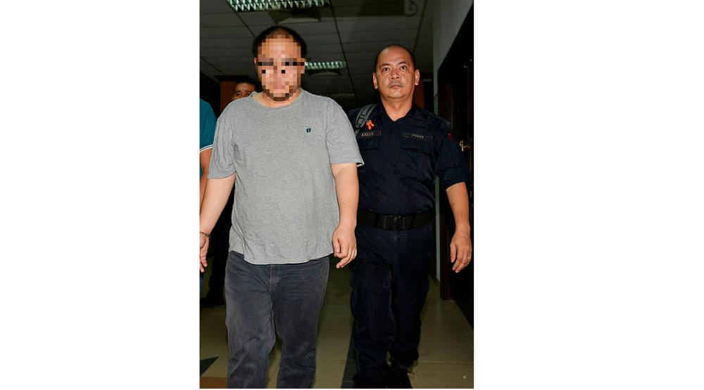 The suspect is led out of Kuching Court, on Feb 24, 2019. — Bernama