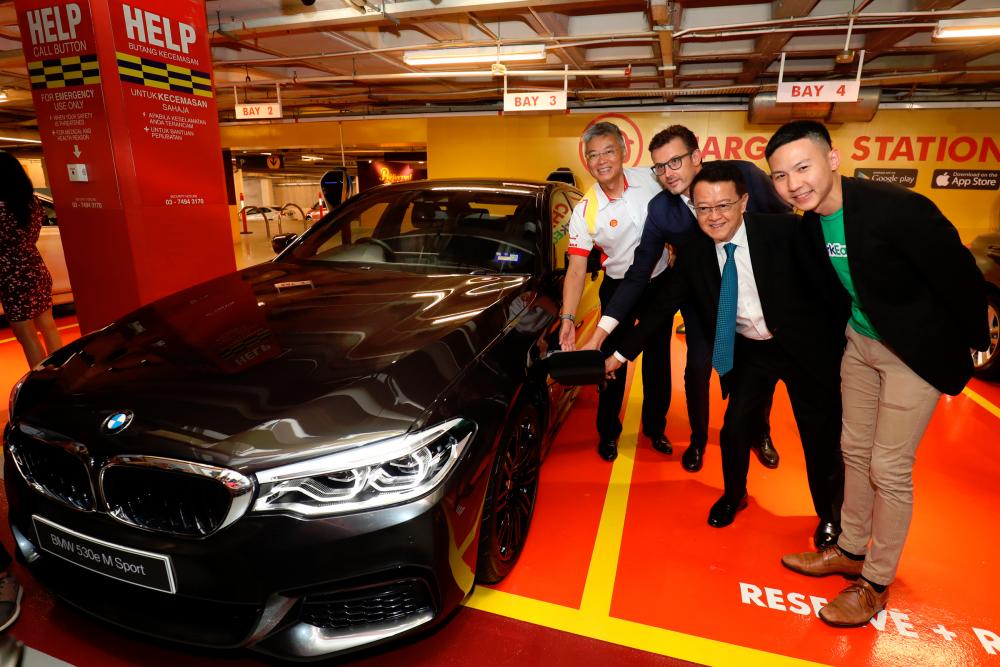 From left: Lo, Hoelzl, Cheah and Chan plugging a charging socket into the charging pod of a BMW 530e M Sport PHEV during the launch at Sunway Pyramid Convention Centre.