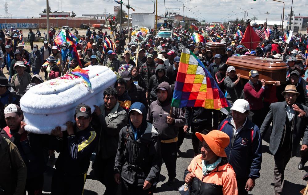 Locals carry two coffins during the funeral procession of eight supporters of Bolivia's ex-President Evo Morales, killed when security forces lifted a siege on a fuel plant, in El Alto, Bolivia, on Nov 21. — AFP